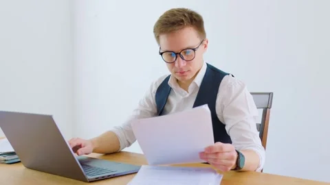 Professional man reviewing documents in modern office setting Stock Footage 305172613