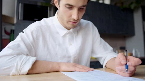 Professional man signs an important agreement carefully reading the terms and Stock Footage 335746161