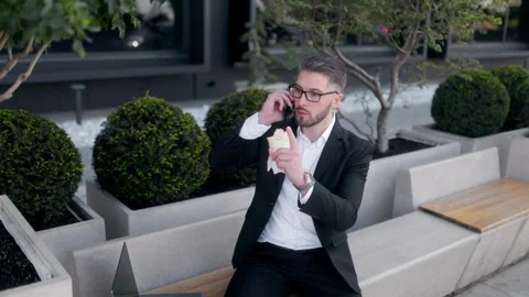 Professional Man in Suit Taking a Lunch Break and Talking on Phone Stock Footage 286139465