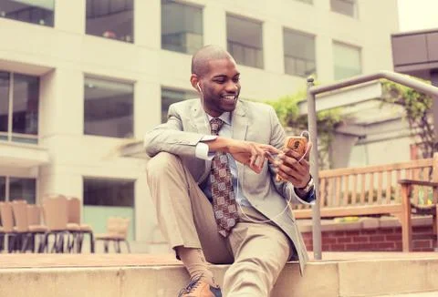 Professional man using smart phone listening to music outdoors Stock Photos