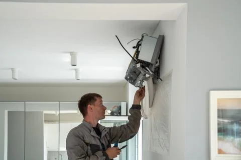 Professional man worker of climate control service in carries out installation Stock Photos