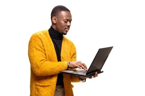 Professional man in yellow sweater using laptop during work task on white Stock Photos