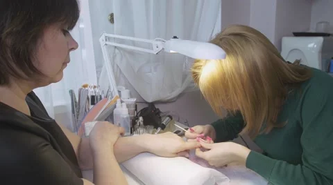 Professional manicurist put off basic from surface of client nails in beauty 库存影片 62874173
