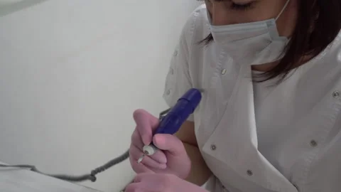 A professional manicurist using a drill tool cuts off old nails close-up. Nail 库存影片 155972889