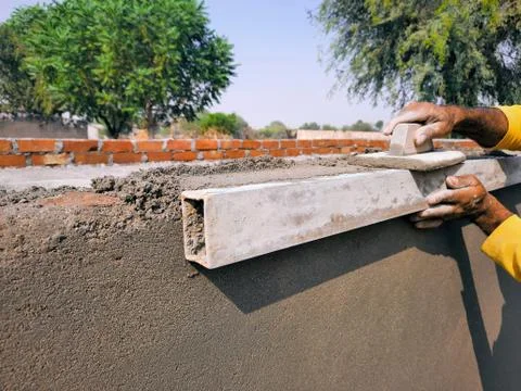 Professional mason building sharp edges of wall with construction tools Stock Photos