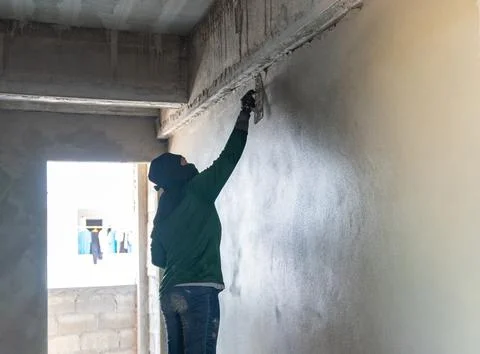 Professional masonry worker applying a smooth cement plaster finish to an i.. Stock-Fotos