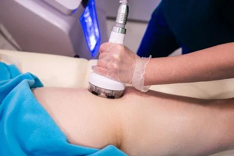 Professional masseuse using modern device for RF lifting procedure, health ca Stock Photos