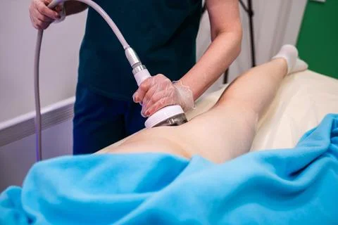 Professional masseuse using modern device for RF lifting procedure, health ca Stock Photos