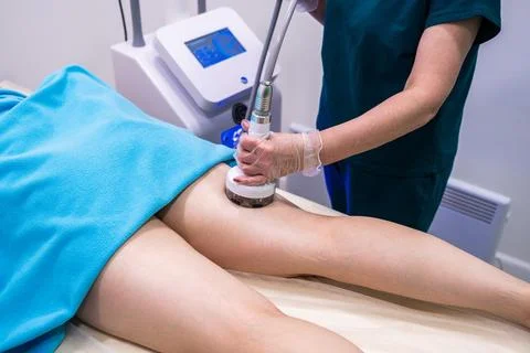 Professional masseuse using modern device for RF lifting procedure, health ca Stock Photos