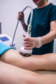 Professional masseuse using modern device for RF lifting procedure, health ca Stock Photos