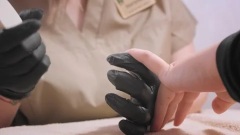 Professional master aligns nail plate polishing with file Stock Footage 247761513