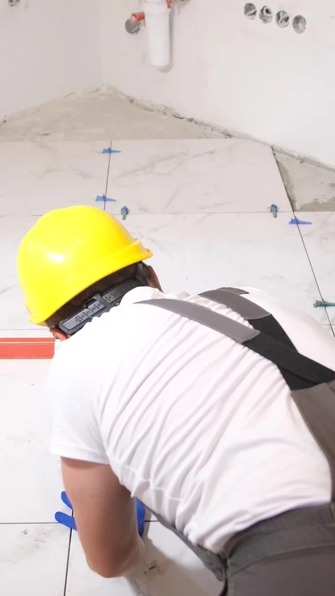 A professional master in laying beautiful ceramic tiles in light tones. Vertical Vídeos de archivo 248357071