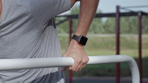 Professional mature athlete doing push-ups on parallel bars wearing smartwatches Stock Footage 94916094