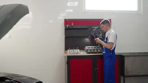 Professional mechanic assembles engine with precision. Expert fits pistons Stock Footage 260716865