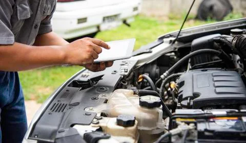 Professional mechanic checking car engine search for data with tablet Stock Photos