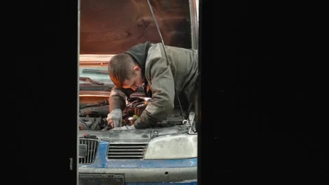 Professional mechanic inspecting vehicle engine in auto repair shop garage Video stock 304675290