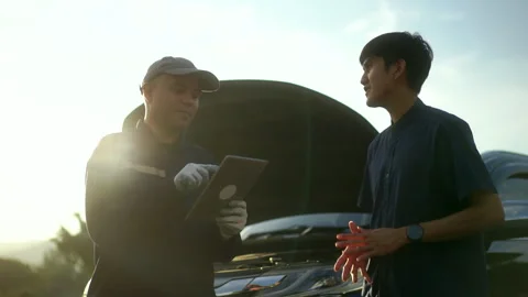 Professional mechanic talking in a conversation with the car owner, explaining. Stock Footage 246271173