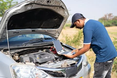 Professional mechanic using laptop for checking car by lifting car hood on Foto stock