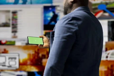 Professional media expert in a high tech space holds green screen Stock Photos