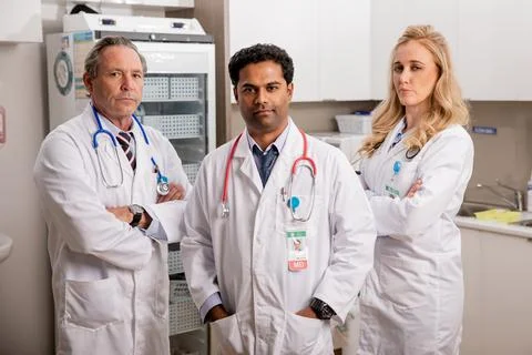 Professional Medical Team of Doctors with White Lab Coats in Hospital Mid Shot Stock Photos
