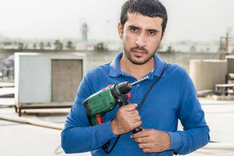 A professional meson is holding his heavy duty drill machine Stockfoto's