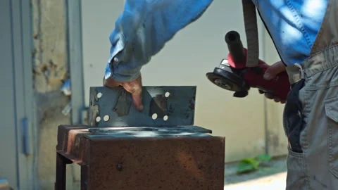Professional Metalworker Using Angle Grinder on Steel Plate in Workshop Stock Footage 337431465