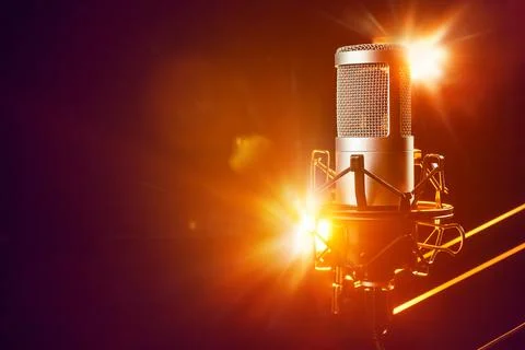 Professional microphone on the stage with orange light beams. Live music, c.. 스톡 사진
