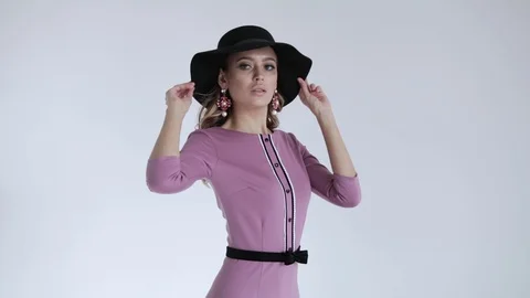 Professional model in black hat in lilac dress and posing on white background Stock Footage 106284068