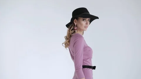 Professional model in black hat in lilac dress and posing on white background Stock Footage 106284093