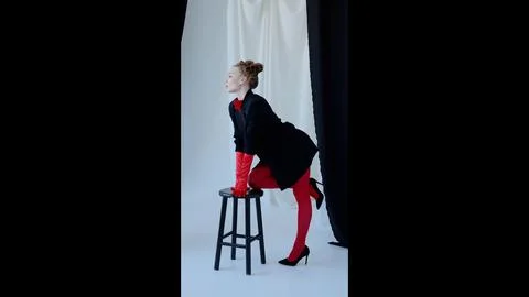 Professional model posing confidently in studio setting, wearing vibrant red Foto stock