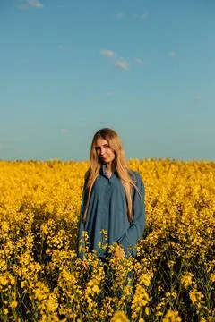 Professional model posing in a rapeseed field at sunset. Model's work, posing Stock Photos