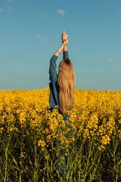 Professional model posing in a rapeseed field at sunset. Model's work, posing Stock Photos