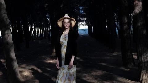 Professional model in yellow straw hat stands in dark forest Stock Footage 121063798
