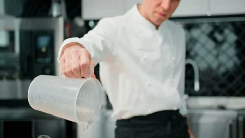 Professional modern kitchen in the restaurant the chef pours water into a pot, Stock Footage 237921145