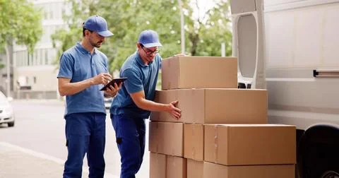 The Professional Mover Unloading Boxes From The Delivery Truck. Foto stock