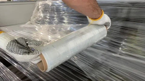 Professional mover wrapping up sofa plastic wrap Stock Footage 141822446