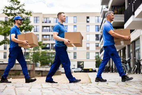 Professional movers are loading a van with boxes to deliver to a new house Stock Photos