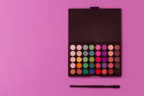 Professional multi-colored eye shadow palette on a light purple background. Stock Photos