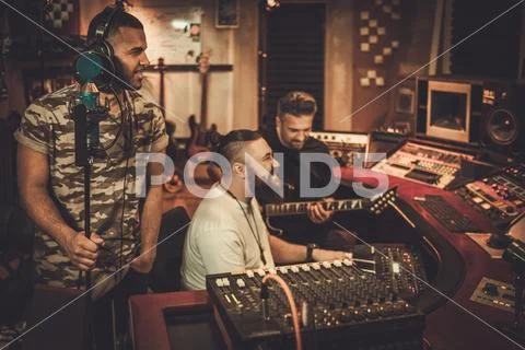 Professional music band recording song in boutique recording stu Stock Photos