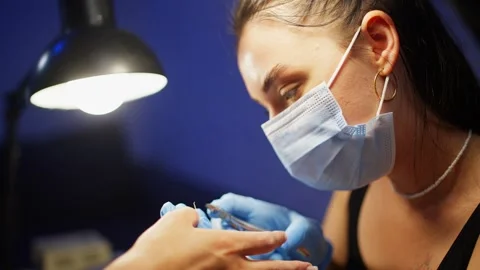 Professional nail technician carefully cuts woman cuticles with manicure nippers Stock Footage 346760371