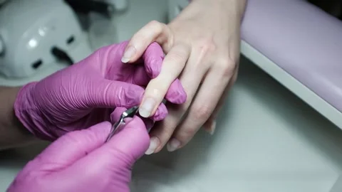 Professional nail technician removing cuticle with professional cutters. Stock Footage 326251999