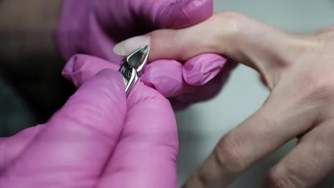 Professional nail technician removing cuticle with professional cutters. Stock Footage 326252000
