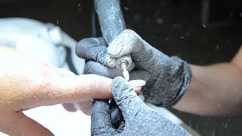 Professional nail technician removing old gel polish with an electric nail drill Stock Footage 340143233