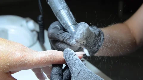 Professional nail technician removing old gel polish with an electric nail drill Stock Footage 340143234