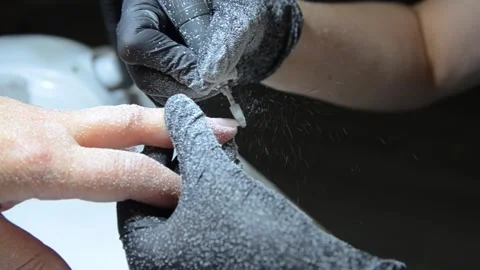 Professional nail technician removing old gel polish with an electric nail drill Stock Footage 340143237