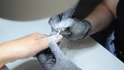 Professional nail technician removing old gel polish with an electric nail drill Stock Footage 340143238