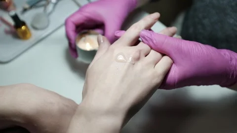 Professional nail technician using candle wax for hand massage after performing  Video stock 326251736