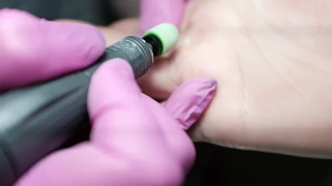 Professional nail technician using electric manicure drill to remove callus from Stock Footage 326252232