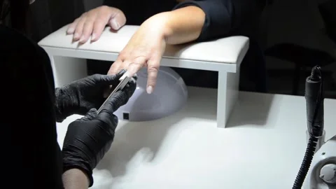 Professional nail technician using a manual nail file to remove old gel polish Stock Footage 340815893