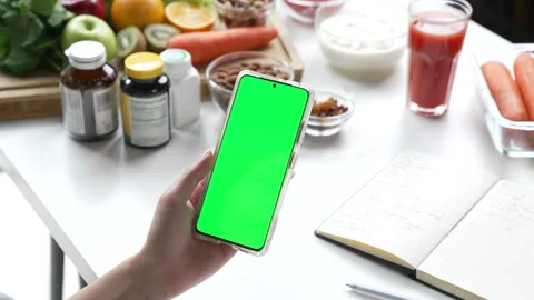 Professional Nutritionist checking data from a phone with green screen Stock Footage 241758496
